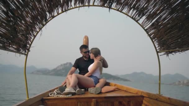 Close-up view of the happy hugging couple resting on the wooden swimming boat along the ocean. Cruise ship vacation. — Stock Video