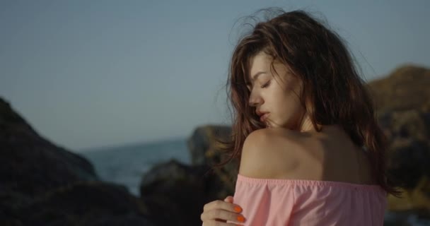 Retrato sensual. Visão traseira de close-up da bela morena encantadora com maquiagem natural olhando por cima do ombro e desfrutando do sol no fundo do mar. — Vídeo de Stock