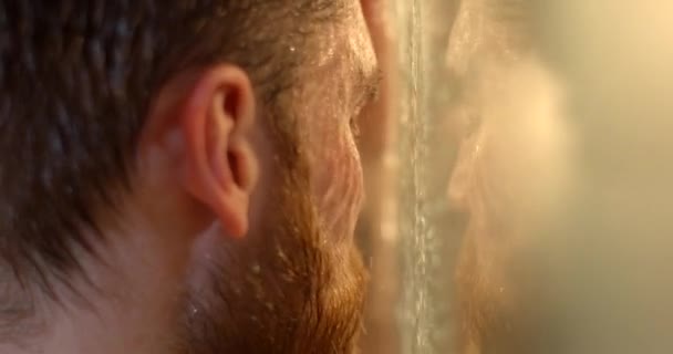 Портрет отчаявшегося красавца с депрессией и гигантской бородой, страдающего в душе. — стоковое видео