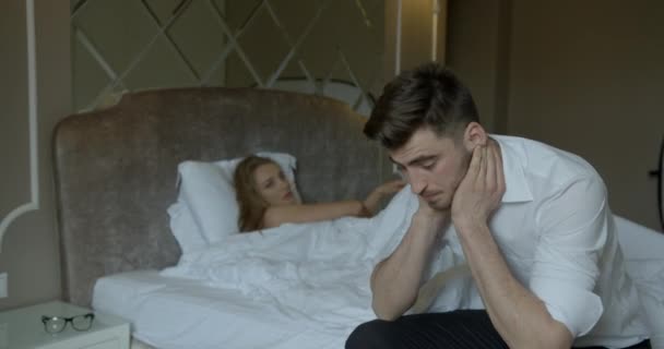 Znepokojuje mladého bruneta kvůli problémům v posteli. Jeho blonďatý milenec v tangách je zklamaný a opouští místnost. — Stock video