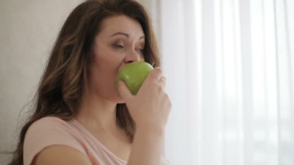 Ritratto laterale della donna obesa attraente che mangia la mela verde con faccia smorzante su una dieta. — Video Stock