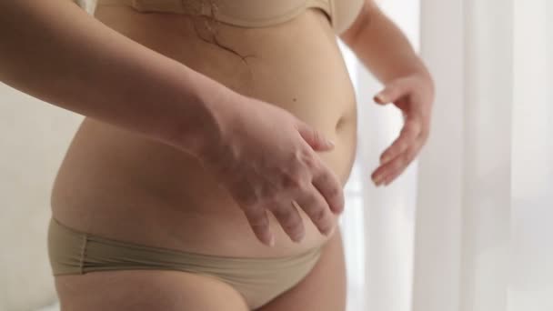 Η παχύσαρκη γυναίκα με τα εσώρουχα αγγίζει το στομάχι της. Χωρίς πρόσωπο. Κοντινό πλάνο. Προβλήματα υγείας και βάρους. — Αρχείο Βίντεο