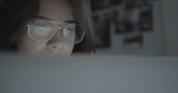 Bizneswoman używa laptopa w biurze. Odbicie grafiki w jej okularach. 4k. — Wideo stockowe