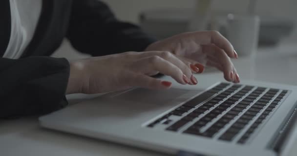 La exitosa mujer de negocios con uñas rojas está escribiendo en la computadora portátil en la oficina. Imágenes de 4k. Mujer desconocida. — Vídeo de stock