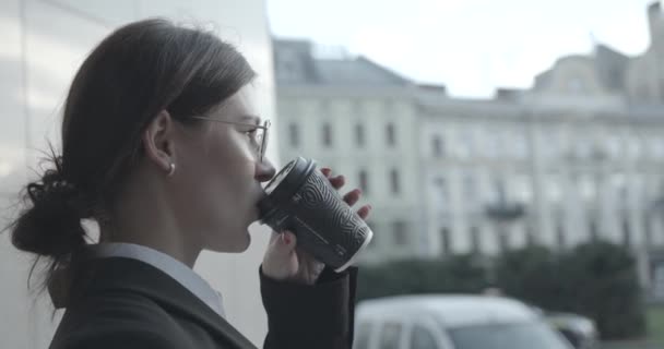 Side portrait of the attractive successful businesswoman drinking coffee and smiling. Outdoor location. 4k. — Stock Video