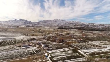 Taurus Dağları yakınlarındaki eski Türk şehrinin üzerinde karla kaplı bir helikopter. Ağır çekim, 4K. Panorama görünümü.