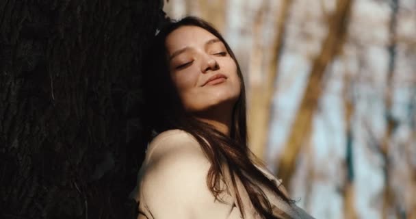 Ambiances d'automne. Adorable jeune femme profite du soleil assis sur la pelouse dans un parc d'automne. Relaxation — Video