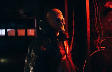 Koruyucu giysi ve gaz maskeli bilim adamı dozimetrist radyasyon danışmanı tehlike bölgesini araştırıyor. Yağmur. Kırmızı.