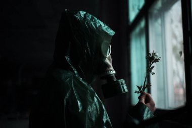 Koruyucu giysi ve gaz maskeli bilim adamı dozimetrist radyasyon danışmanı tehlike bölgesini araştırıyor. Yakın plan. Çiçek.