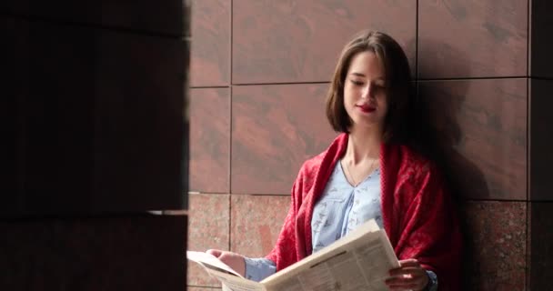 Όμορφη γυναίκα διαβάζει εφημερίδα στην πόλη. Βίντεο 4K. — Αρχείο Βίντεο