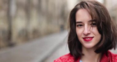 Çekici bir kadının yakın portresi. Gülümseyen esmer, kendine güvenen güzel. 4K video.