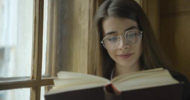 Bayan öğrenci, kütüphane. Güzel genç kız öğrenci bir kitap okuyor.