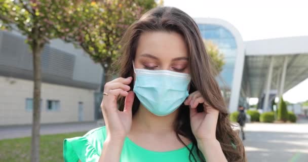 Gros plan portrait jeune femme heureuse enlève le masque de protection du visage en regardant la caméra et respire l'air frais. Concept de virus, épidémie ou pandémie. — Video