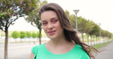 Güzel bir kadının yakın plan portresi kamerada görünüyor. Rüzgâr saçlara eser. 4K atışı. Yüzünü kapat.