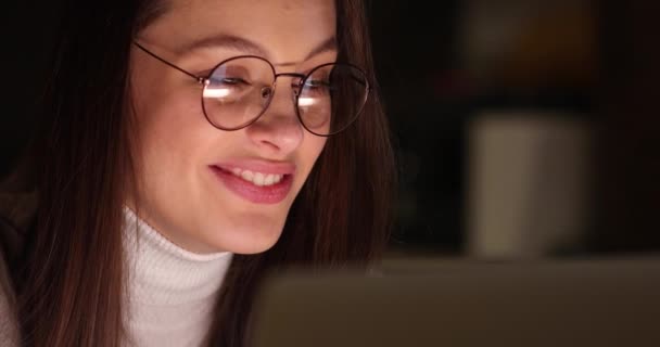 Close-up do rosto de uma jovem atraente que trabalha em um computador. Coronavírus, pandemia, auto-isolamento de quarentena — Vídeo de Stock