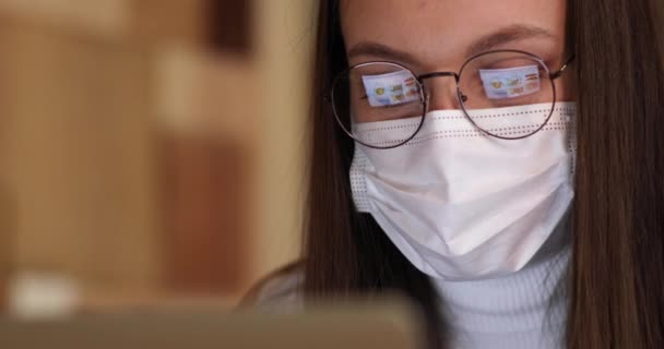 Nah am Gesicht einer attraktiven jungen Geschäftsfrau, die an einem Computer arbeitet, in dessen Brille Grafiken abgebildet sind — Stockvideo