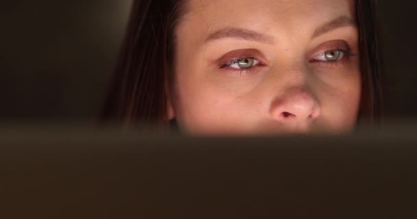 Close-up retrato de uma mulher com belos olhos verdes, que os abre e observa em skreen de computador — Vídeo de Stock