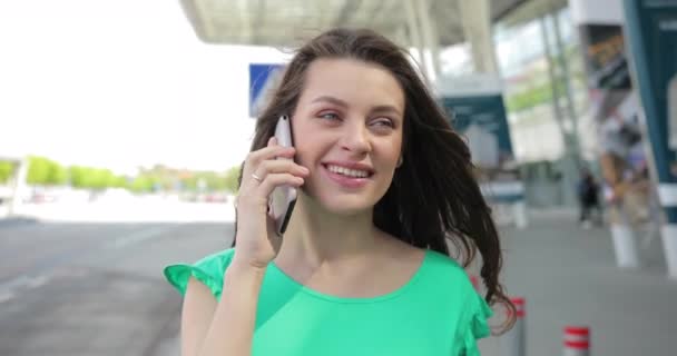 Portrét atraktivní mladé ženy s dlouhými krásnými vlasy a okouzlujícíma očima mluvící po telefonu — Stock video