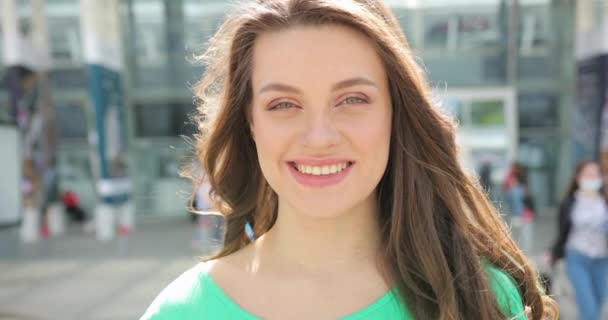 Een close-up portret van het gezicht van een aantrekkelijk natuurlijk mooi meisje dat recht in de camera kijkt en glimlacht — Stockvideo