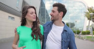 Çekici gülümseyen insanlar sarılmaya ve konuşmaya giderler. Genç ve güzel bir çift yürüyor