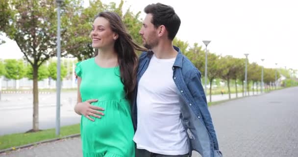 Joyeux couple enceinte marchant étreignant et se tenant la main. Heureuse femme enceinte. Un couple amoureux attend la naissance d'un bébé — Video
