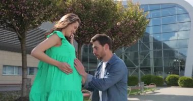 Mutlu müstakbel baba hamile karısının karnını dinliyor..