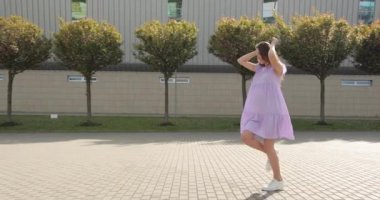 Hamile bir kadın mutlu olur. Hamile bir anne kucağında bebeğiyle sokakta yürürken eğleniyor.