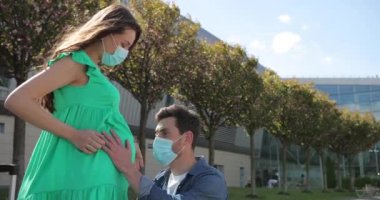 Annem ve babam koruyucu maskeler takmış, elleri hamile karnında. Hamile bir çift hamile bir göbeği okşar. Müstakbel annenin bakımı. Annelik kavramı. Hamilelik. Mutlu bir aile..