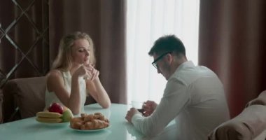 Pencerenin yanındaki masada kahvaltı yapan çift. Adam kahve ya da çay içer. Kadın biraz saçmaladı. Gençler kahvaltı sırasında konuşuyor