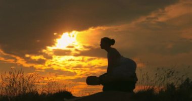 Bir erkek ve bir kadın mutlulukta meditasyon yaparlar. Genç yoga hocaları çim üzerinde bir parkta pratik yapıyor. Başarılı gençler akro yoga egzersizleri yapıyorlar. Yakın çekim..
