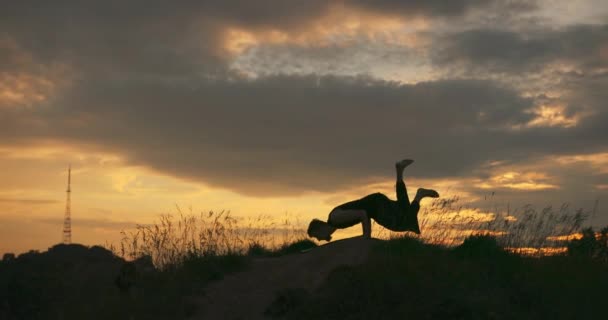 Jonge barefoot baard man met presteert yoga Asan in de avond bij zonsondergang. In harmonie met de natuur. — Stockvideo