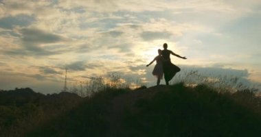 Dışarıda gün batımının güzelliğiyle yoga ağacı pozisyonu alan iki kişi. Çift, Clody Sky 'ın arka planında poz veriyor. Güzel doğa..