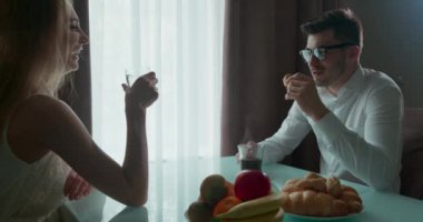 Pencerenin yanındaki masada kahvaltı yapan çift. Ay çöreği yiyen bir adam. Kadın biraz saçmaladı. Gençler kahvaltı sırasında konuşuyor