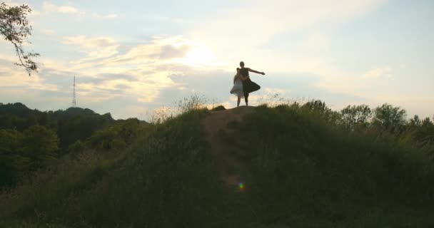 Två personer tränar yoga trädposition utomhus med vacker solnedgång. Par gör pose träd tillsammans bakgrund clody himmel. — Stockvideo