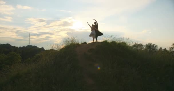 Close up of partners standing beside each other and performing double tree pose. On the subjekt of beautiful nature and cloudy sky. — Stock Video