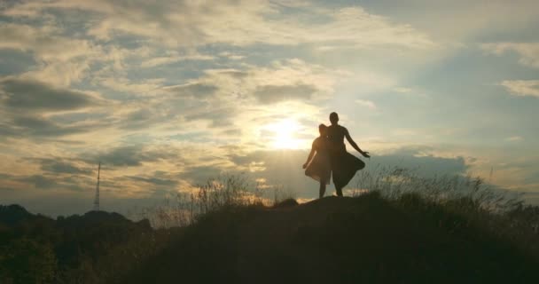 Närbild av partners som står bredvid varandra och utför dubbla träd utgör. På subjekt vacker natur och molnig himmel. Ärtor i själen och harmoni med naturen. Vacker solnedgång. — Stockvideo