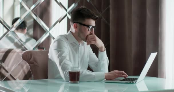 Fiatal férfi használ laptop tanul online dolgozik otthonról az interneten, mosolygós fókuszált Y-generációs srác gépelés a számítógépen szörfözés web nézi képernyőn élvezi a távoli munkát. — Stock videók
