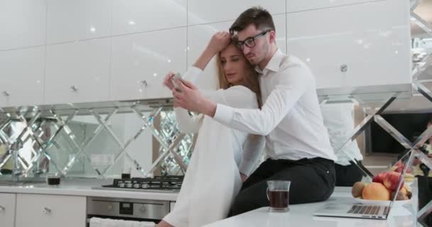 Rolig pojkvän och flickvän roterar gör selfie hemma på ett kök. Lyckligt och leende. — Stockvideo