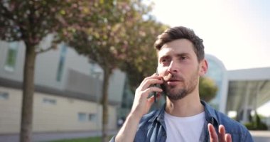 Dışarıda telefonla konuşan yakışıklı bir adam portresi. Sokakta akıllı telefondan konuşan bir iş adamı. Mutlu adam dışarıdaki telefonu arıyor. Ofis çalışanı dışarıda konuşuyor..