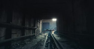 Metalik bir bara karşı şınav çeken sarışın bir fitness mankeni..