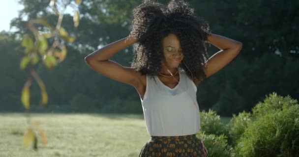 Portret Emocjonalny Szczęśliwy Uśmiech Ładny Afro American Girl Energicznie Taniec Słuchanie Cieszący się muzyką Słuchawki wstrząsające Dotknięcie Ciemne kręcone włosy 4k Powolny ruch na świeżym powietrzu. — Wideo stockowe