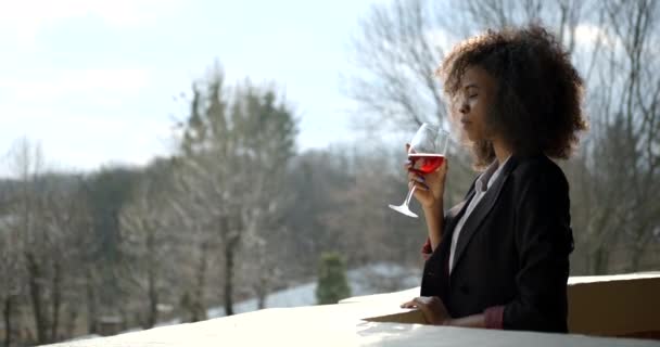 Retrato lateral da bela mulher afro-americana no terno beber vinho na varanda. Vista da paisagem. — Vídeo de Stock