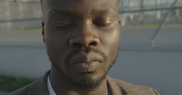 Närbild porträtt av den lugna stiliga afrikanska mannen öppna ögon och titta i kameran. 4k-bilder. — Stockvideo