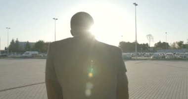 Şık giyinmiş mutlu Afro-Amerikan adam komik bir şekilde sokakta güneşlenerek dans ediyor. 4k görüntü.