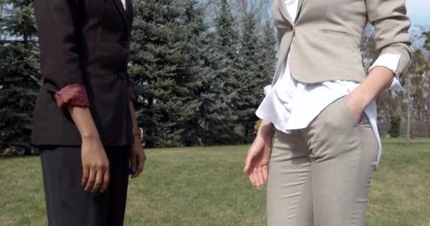 Närbild av den afro-amerikanska affärskvinnan som skakar hand med den kaukasiska. Plats utomhus. — Stockvideo