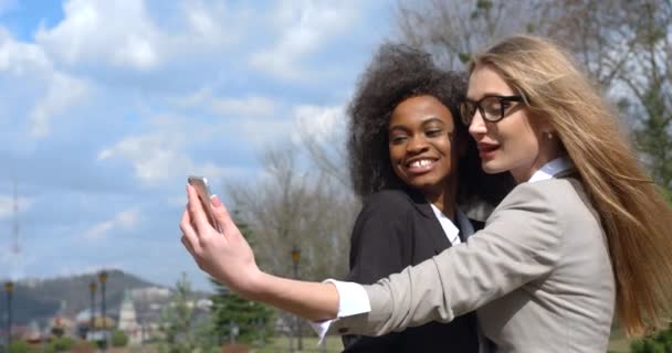 Close-up portret Afrikaanse Kaukasische collega 's zakenvrouwen multi race pakken poseren het nemen van selfie glimlachen buiten 4k jong mooi. — Stockvideo