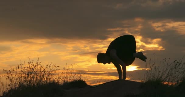 El hombre hace yoga al atardecer. Asana Bakasana, pose Grulla. — Vídeos de Stock