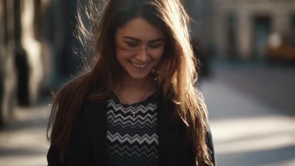 Portrait de la belle fille charmante avec maquillage naturel et joli sourire marchant le long de la rue ensoleillée. — Video