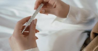 Bacalı, kimliği belirsiz bir kadının elinde termometre var. Vücut ısısını kontrol ediyorum. 4k görüntü.