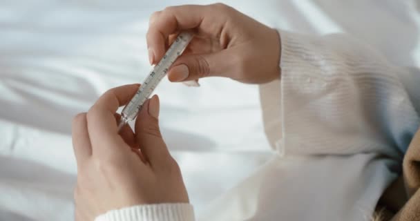 Close-up van de thermometer in de handen van de onbekende zieke vrouw. 4k-beelden. — Stockvideo